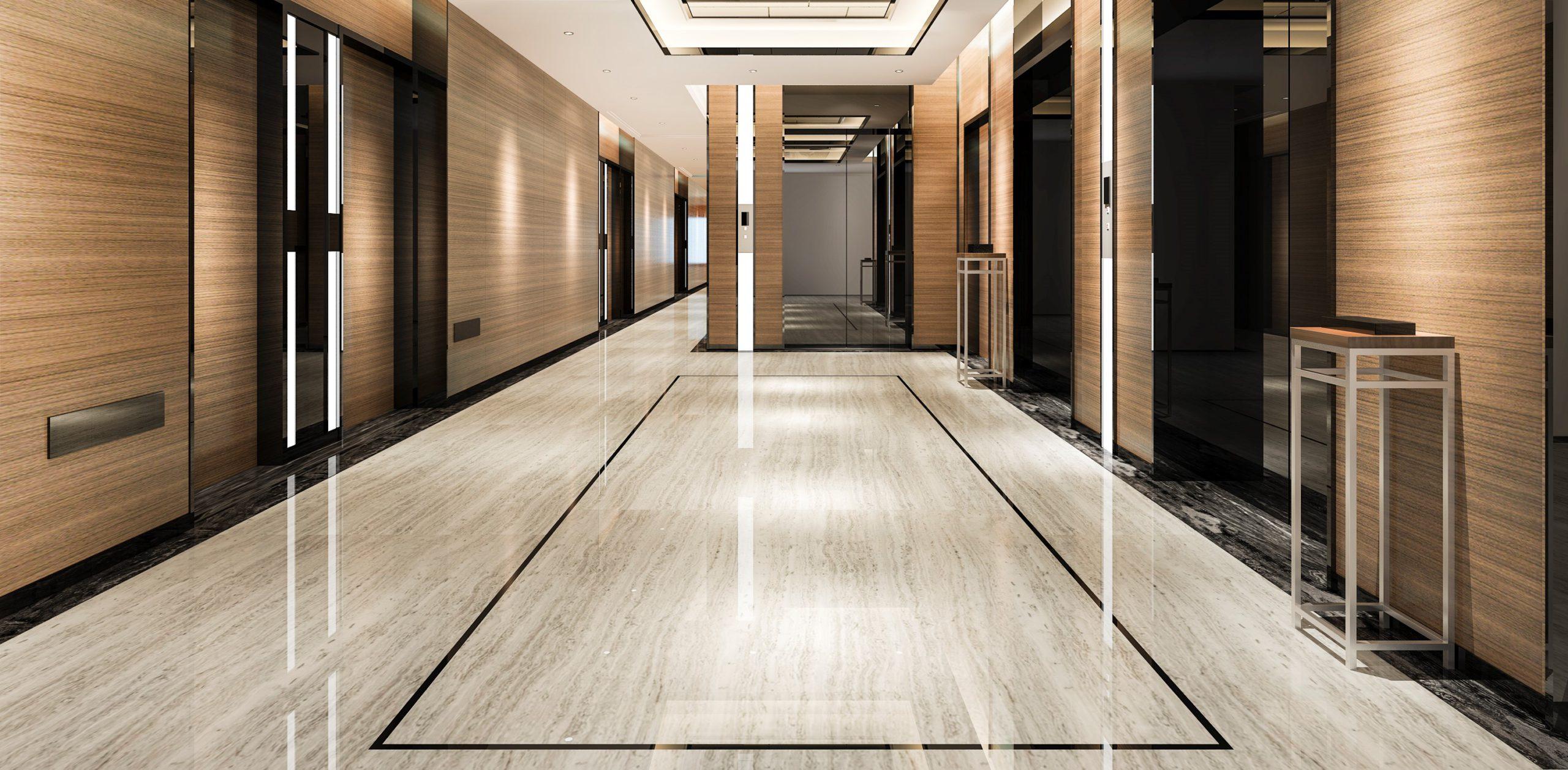 Modern hotel corridor featuring polished marble flooring, elegant lighting, and stylish wooden paneling, creating a sophisticated and inviting atmosphere.